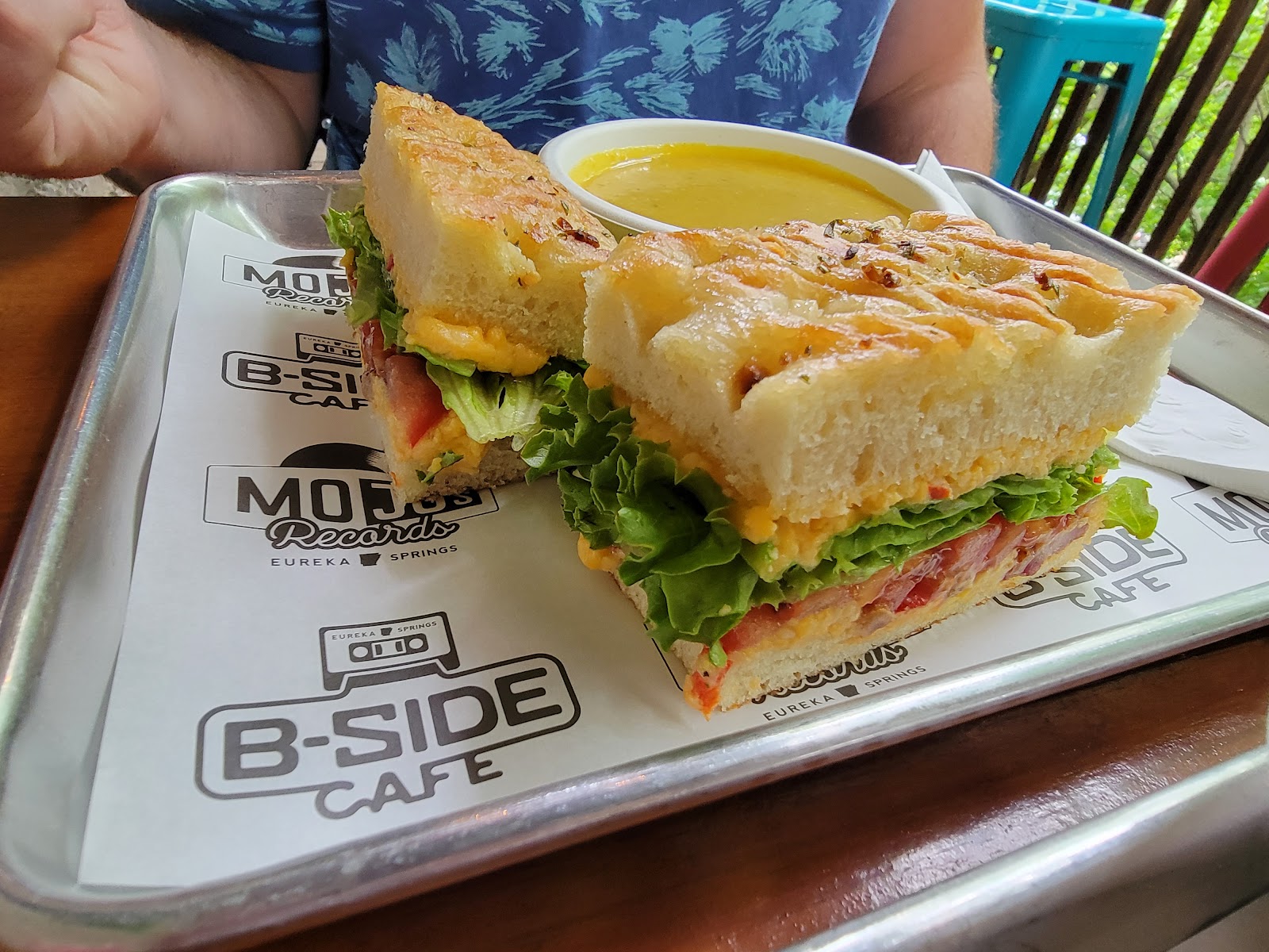 Sandwich and soup on a tray bearing B-Side Cafe branding